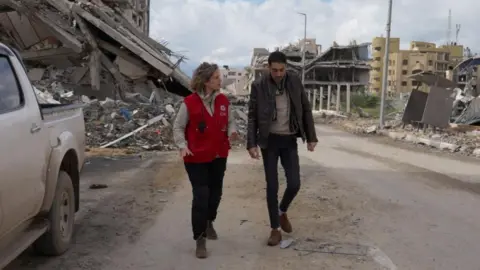 Reuters Image shows Hisham al-Sayed walking with a member of the Red Cross as he is released by Hamas