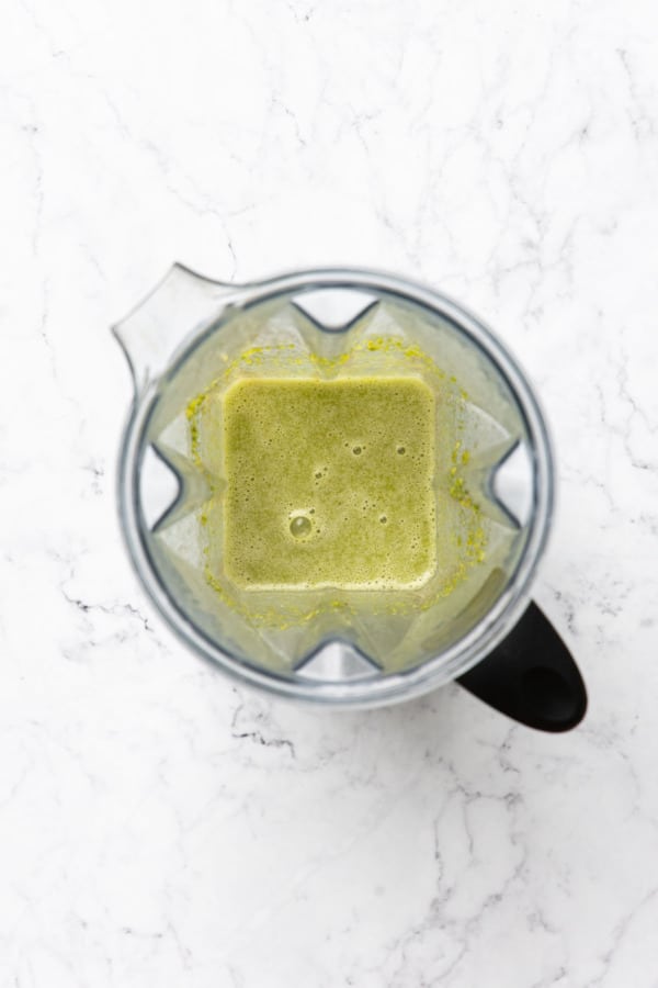 Top down view of blender canister with pistachios and sugar syrup after blending, the mixture is very smooth.