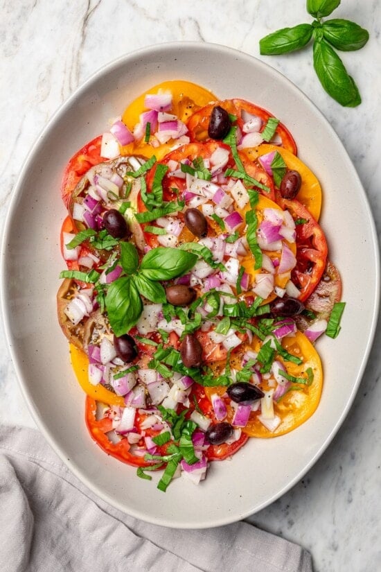 Overhead view of heirloom tomato salad with basil and kalamata olives