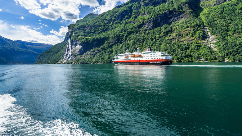 A Hurtigruten ship sails down a Norwegian fjord