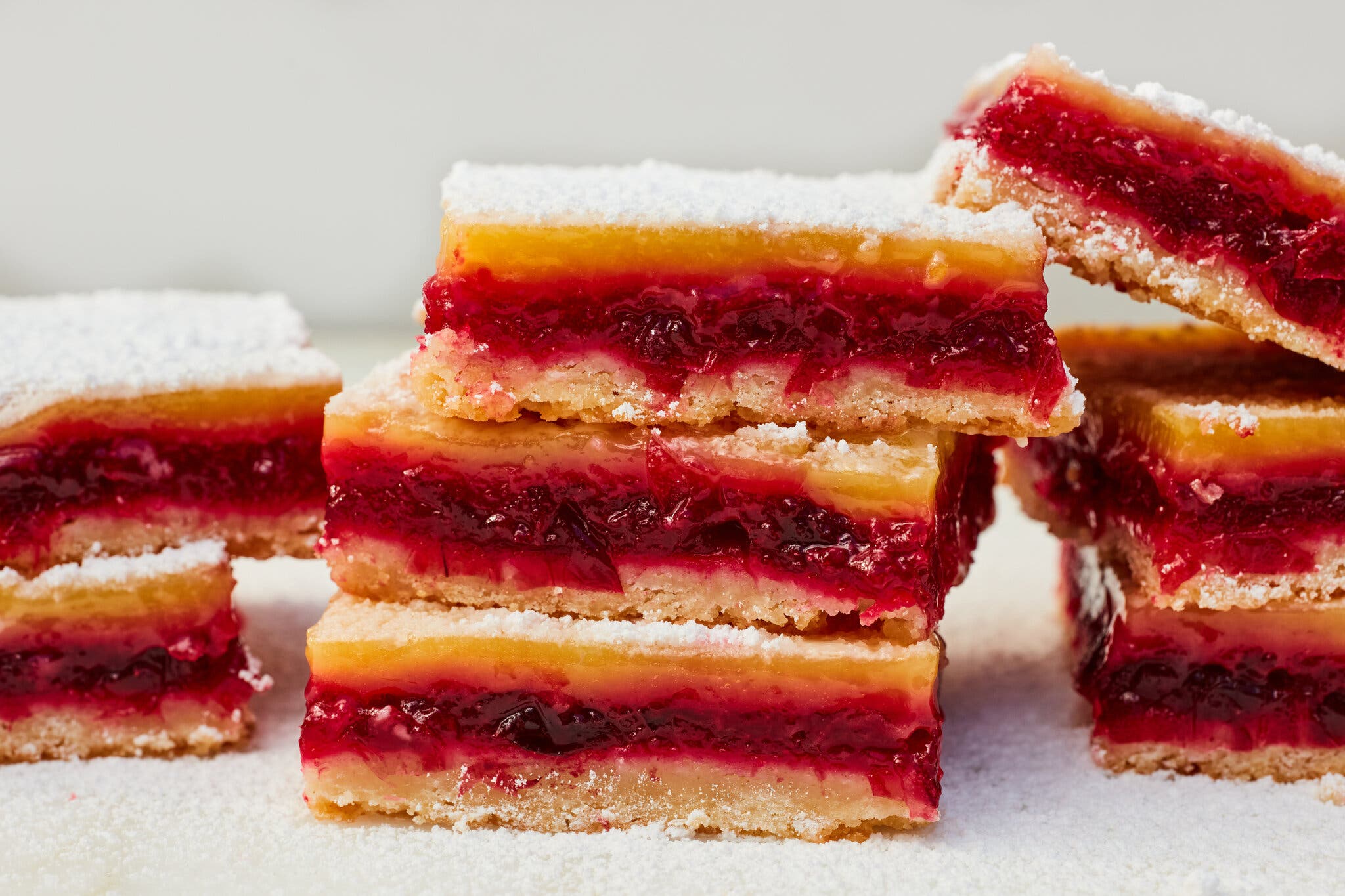 A side image of lemon bars filled with a cranberry curd.