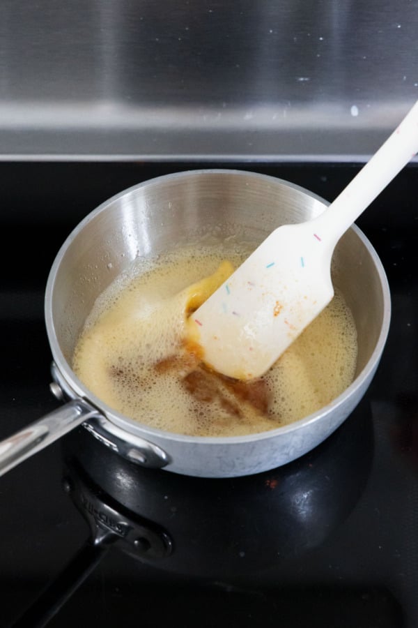 After browning, the foamy melted butter will have golden brown solids settled on the bottom.