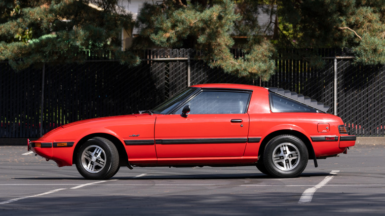 A red rotary-powered RX-7 sportscar in a parking lot