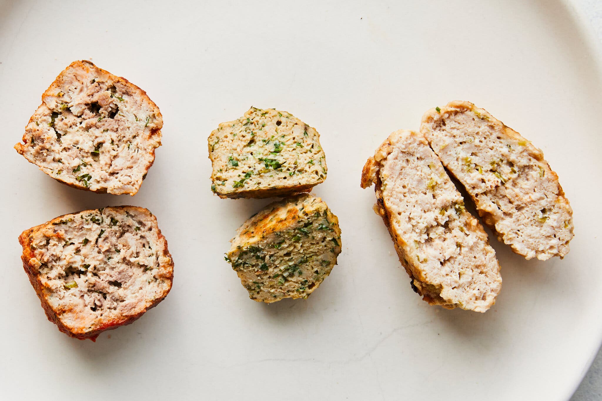 An overhead image of three meatballs sliced in half.