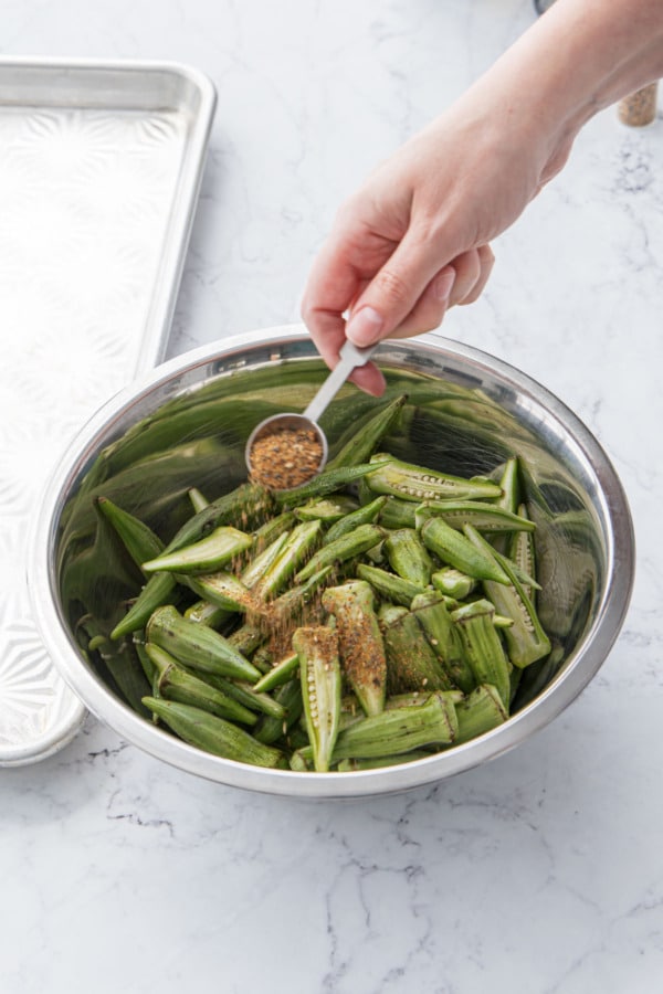 Sprinkling okra with togarashi seasoning.