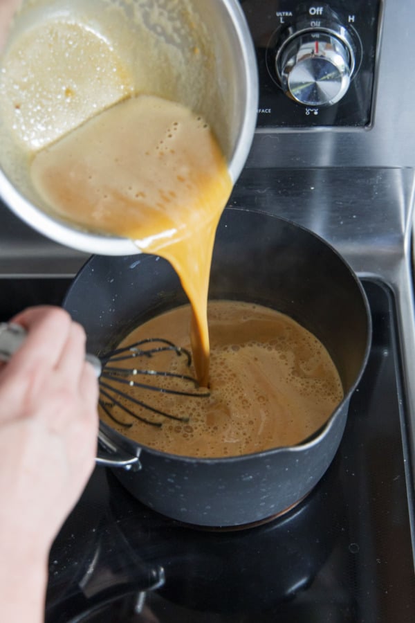 Pouring egg yolk mixture back into the saucepan.