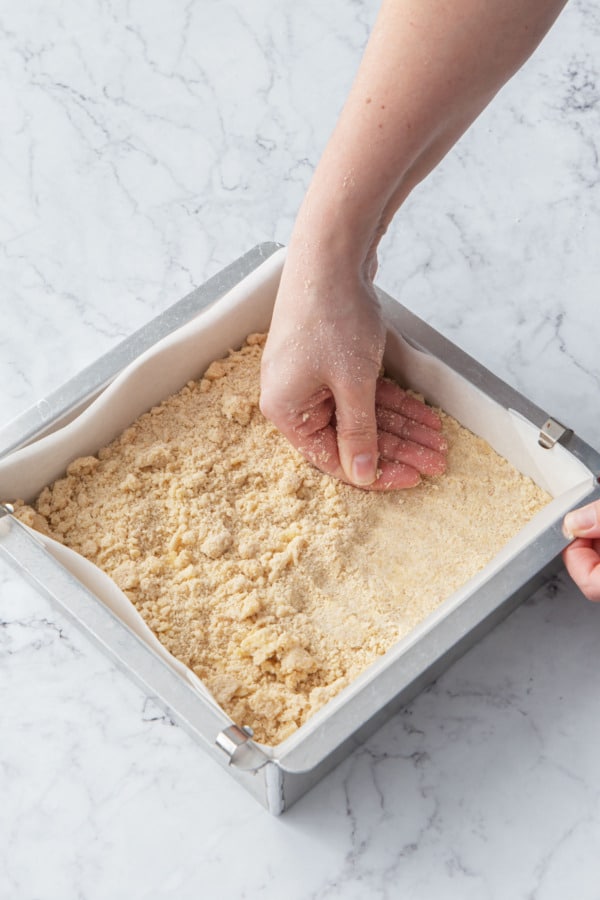 Pressing the shortbread dough into the baking pan.