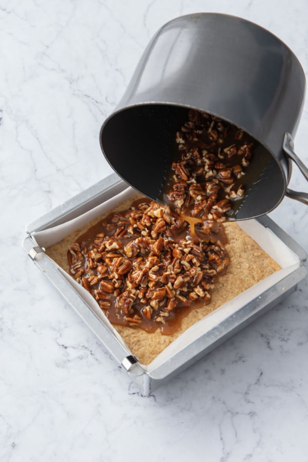 Pouring filling onto pre-baked shortbread layer.
