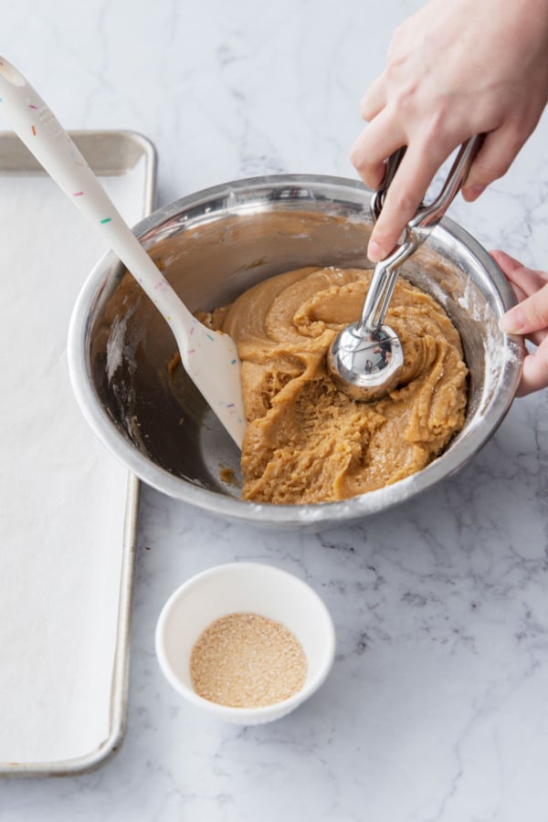 Scooping the maple cookie dough with a medium cookie scoop.