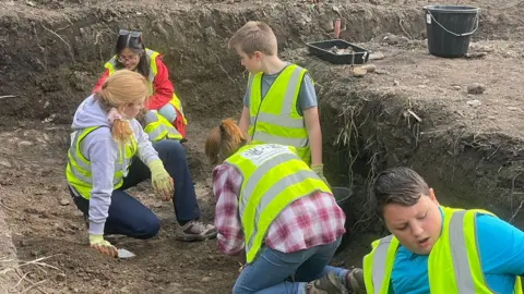 Swansea University School pupils help excavate land to the west of Margam Abbey Church as part of the ArchaeoMargam project